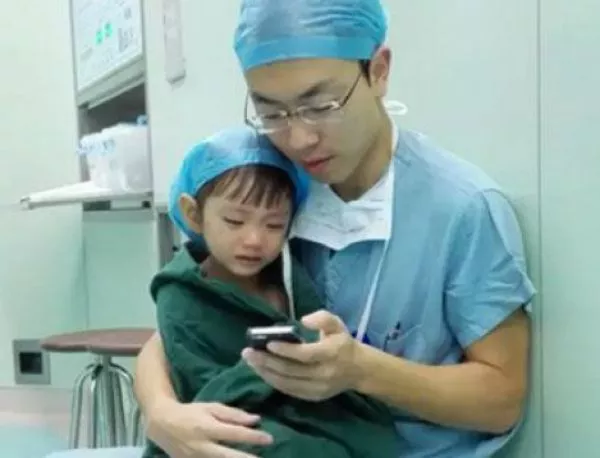 Млад лекар успокоява детенце преди сърдечната му операция