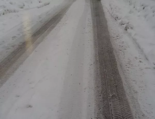 Автобус разтовари пътуващи в снега, насред кръстовище между три села